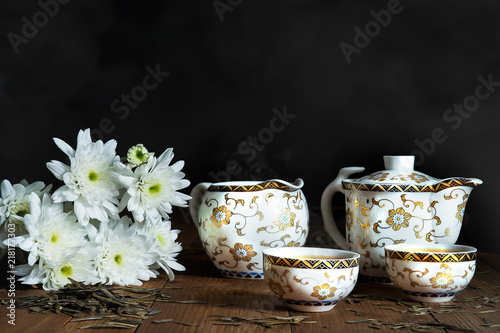 Still life of porcelain tea set of pot, jar and cup with ...