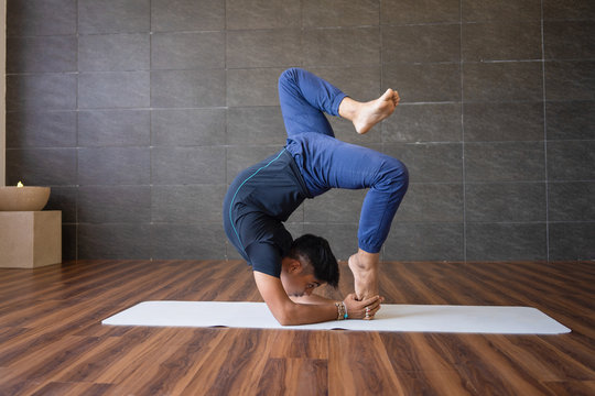 Yogi Doing Difficult Hand Stand Yoga Pose In Gym. Man Practicing Advanced Yoga. Yogi Concept.