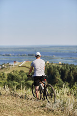 Cyclist. A young man on a Bicycle. Resting and admiring the scenery