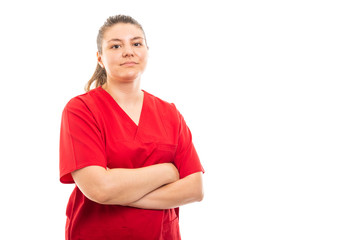 Young medical nurse wearing red scrub standing with arms crossed.