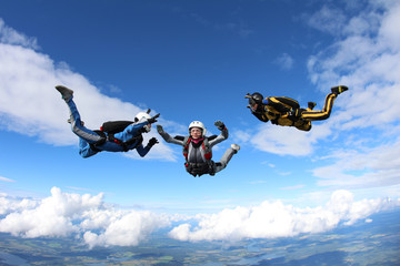 Skydiving. Two instructors are training a student to fly.