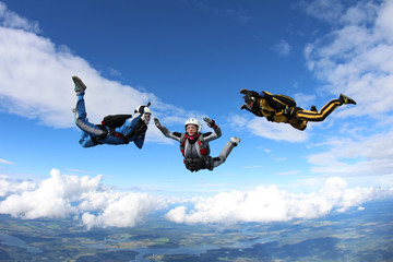 Skydiving. Two instructors are training a student to fly.