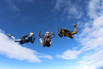 Fototapeta na wymiar Skydiving. Two instructors are training a student to fly.