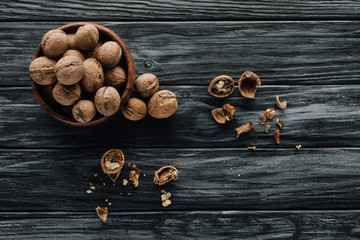 organic walnuts in wooden bowl on dark wooden table