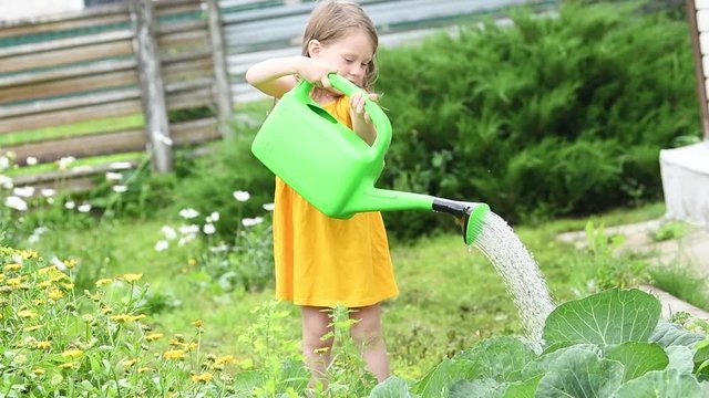 little girl watering garden plants