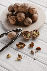 delicious walnuts with metal nutcracker on wooden table