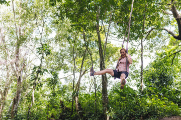 A female tourist swings like a tarzan through the jungle - Minca/ Magdalena /Colombia