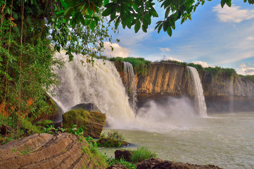 Dray Nour waterfall, against the blue sky, among the green equatorial vegetation, Daklak province, Vietnam