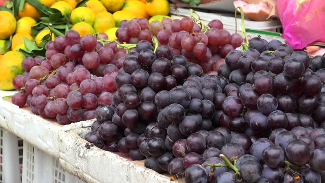 Bunches of grapes with flying wasps on the open air farmers market. 