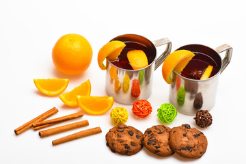 Drink or beverage with cinnamon sticks, orange fruit and cookies with chocolate drops. Drink of...