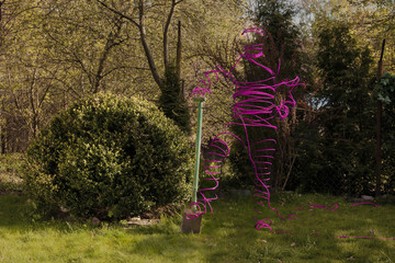 różowa postać w ogrodzie