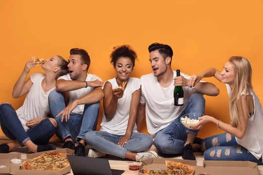 Multiracial people having fun, eating pizza.