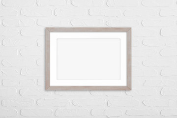 Wooden photo frame mock up on white bricks wall. Home, office, studio or gallery interior decoration 