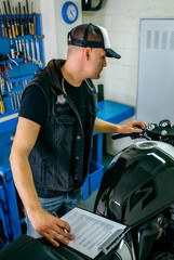 Mechanic checking motorcycle and taking notes