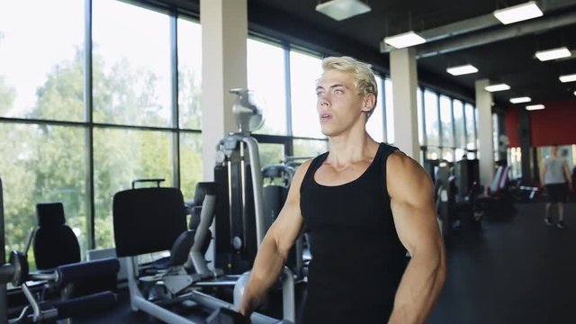 Sporty man with dumbbells training in gym - sport, fitness, bodybuilding concept