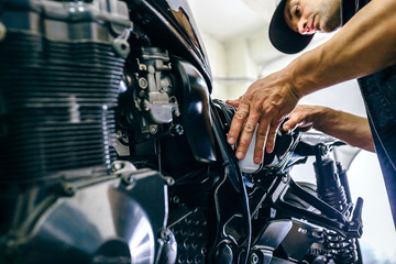 Mécanicien réparant une moto personnalisée dans l& 39 atelier