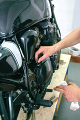 Mechanic repairing customized motorcycle in the workshop