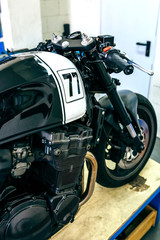 Fototapeta na wymiar Detail of handlebar and gas tank of customized motorcycle in the workshop
