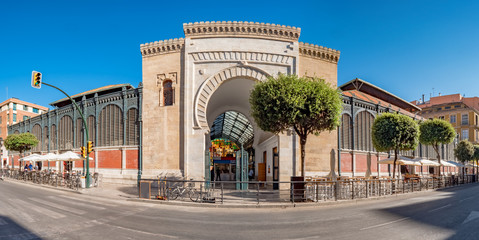 Panorama view of the Arabic marble arch, entrance of the Atarazanas food market in the historic centre of the city of Malaga, Spain - obrazy, fototapety, plakaty