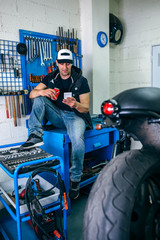 Custom motorcycles mechanic resting having a beer in his workshop