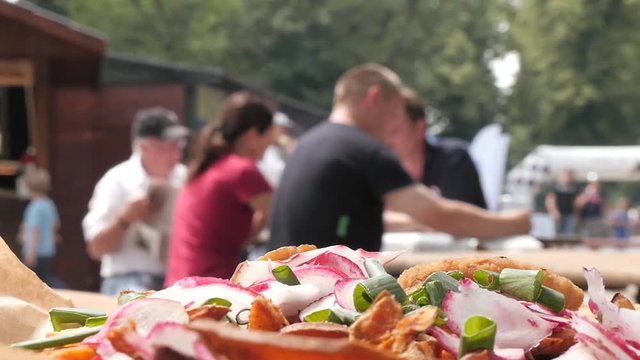 People sitting eating, drinking and talking on Street Food Festival - Summer Day