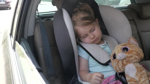 Cute Little Child Girl sleeps in a Car Chair - Hot Summer Day
