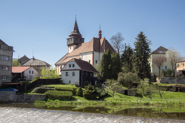 Fototapeta na wymiar Church of St. Wenceslas in town Svetla nad Sazavou, clock tower, greenery and blue sky, river Sazava