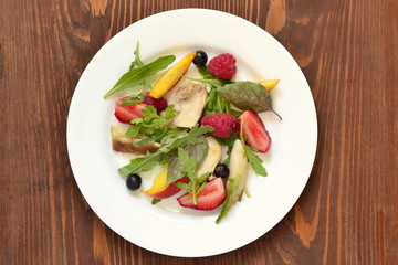 Chicken salad with fresh berries and arugula, top view