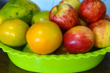 bowl with ripe fruit, apple, orange, papaya