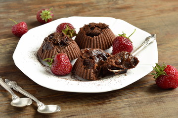 Delicious chocolate souffle with prunes and strawberries sprinkled with cocoa