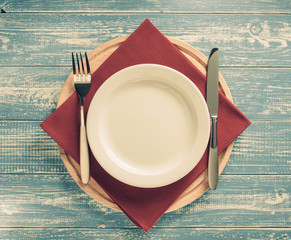 plate, knife and fork on rustic background