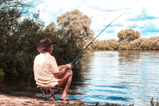 A man is fishing on the shore of a lake. Fishing. Fishery