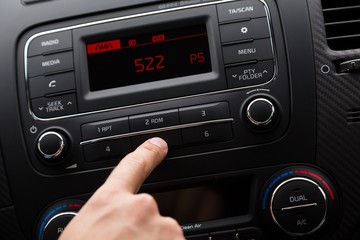 Closeup of a Hand Pressing a Button of a Car Audio System