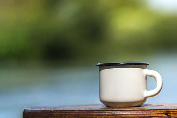 A metal cup on a background of nature.