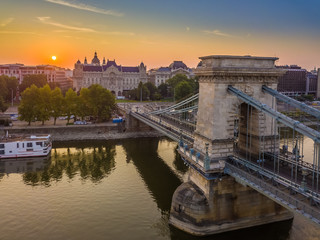 Naklejka premium Budapest, Hungary - Aerial view of the Szechenyi Chain Bridge at sunrise with St. Stephen's Basilica at background