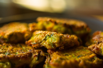 Fried vegetable fritters with zucchini, carrots, herbs, eggs, and cheese.