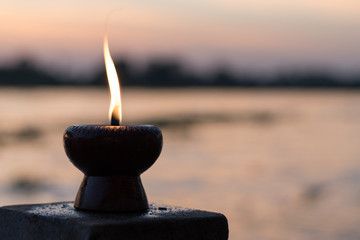 Candle light fire lamp nearby abstract background river during sunset or sunrise in countryside....