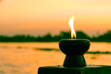 Candle light fire lamp nearby abstract background river during sunset or sunrise in countryside....