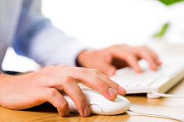 Closeup of an Employee Typing on Keyboard and Holding Mouse
