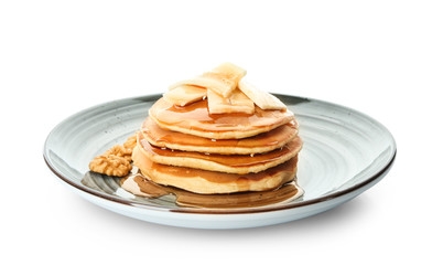 Plate with tasty pancakes, walnuts and sliced banana on white background