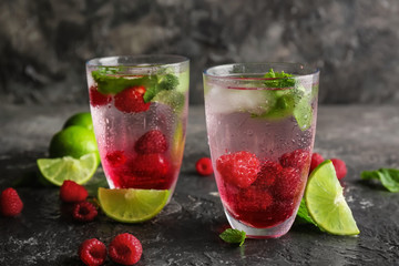 Glasses of fresh raspberry mojito on table