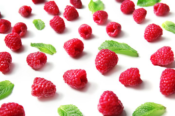 Fresh ripe raspberries with mint leaves on white background
