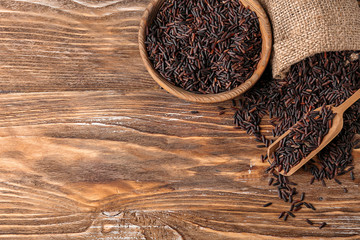 Composition raw wild rice on wooden background
