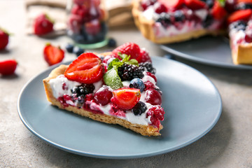 Plate with piece of delicious berry pie on table