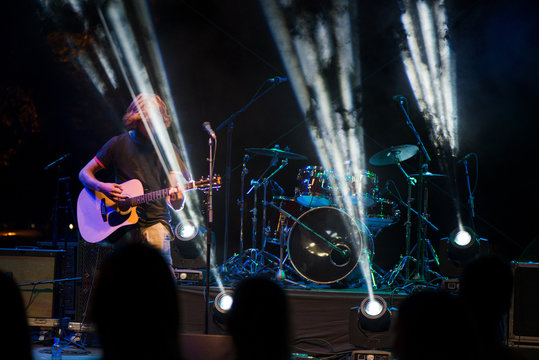 Unrecognisable male musician on stage performing his new songs. Artist with great vocals and beautiful voice.  
