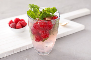 Glass of fresh raspberry mojito on light table