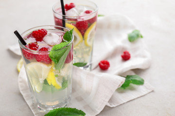 Glasses of fresh raspberry mojito on light table