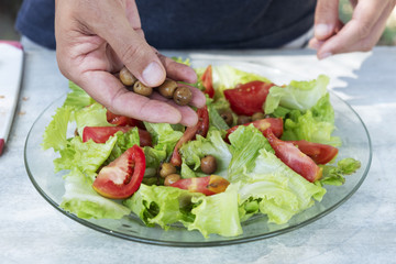young man preparing a green salad