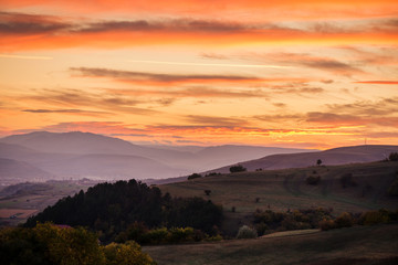 Romantic, bright and colorful sunset over a mountain range in Transilvania. Beautiful, colorful autumn background