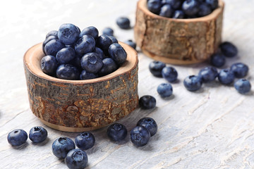 Bowl with ripe blueberries on wooden table